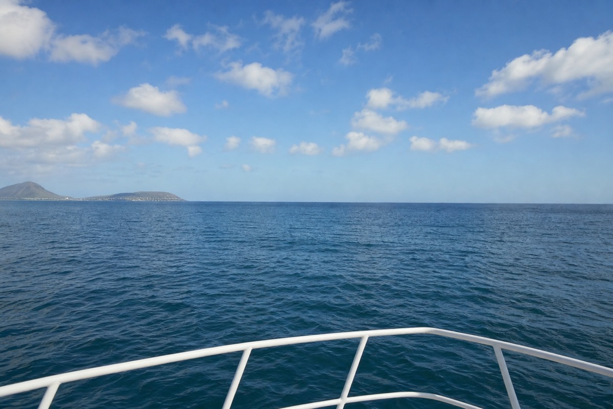 View toward the open ocean horizon from the bow of a boat